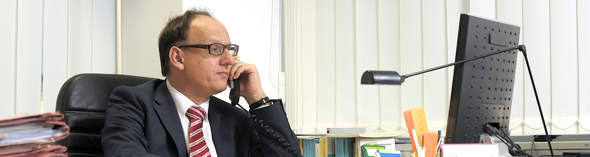 Rechtsanwalt Martin Feickert am Schreibtisch im Telefonat
