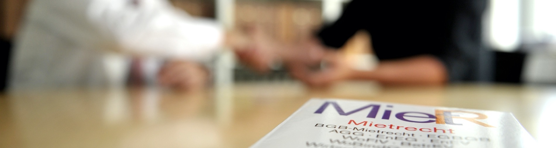 Handschlag beim Vertragsschluss, Mietrechtsbuch im Vordergrund
